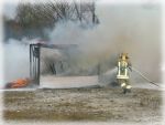Symbol f�r Archiv - Feuerwehrmann beim l�schen einer kleinen H�tte